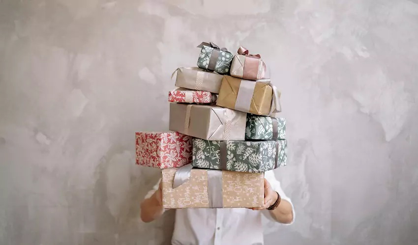 Man holding presents stacked high